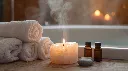Ultra-realistic 8K scene of a glowing white Himalayan salt tealight candle holder placed beside rolled towels, spa stones and essential oils near a bathtub. Soft steam rising, warm candle glow creating a calmi (1).webp