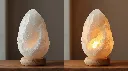 Create a high-quality 1_1 product image of a Himalayan White Salt Lamp inspired by the reference images_ a naturally shaped, uneven handcrafted white salt rock with a slightly translucent texture. The lamp must ap.webp